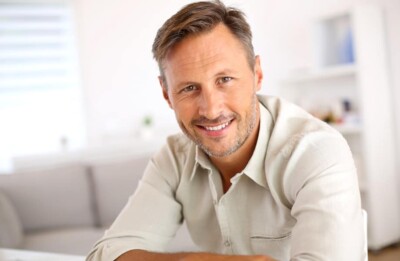 A happy man with dental crowns / tooth crowns in Burke, Virginia.